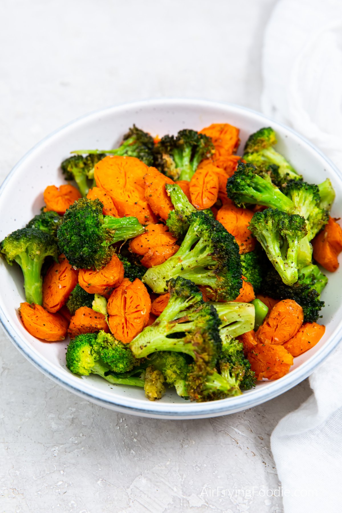 Air fried broccoli and carrots in a bowl, ready to eat.