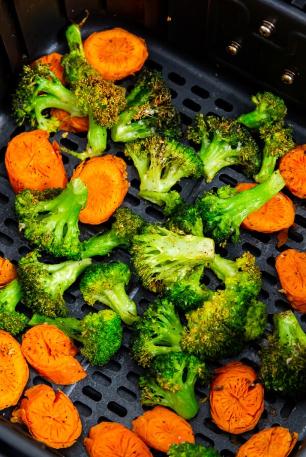 Broccoli and carrots in the basket of the air fryer.