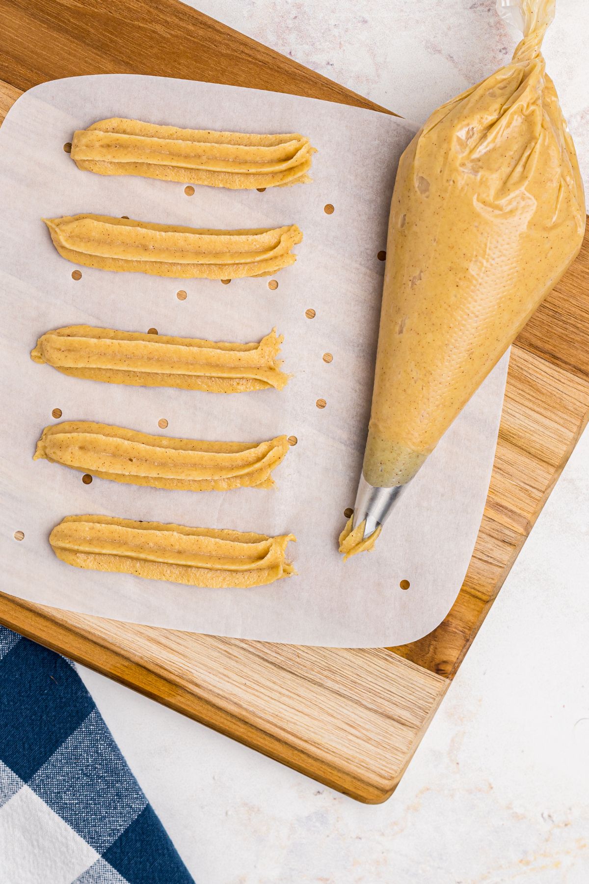 Churro dough in a piping bag after piping churros on parchment paper