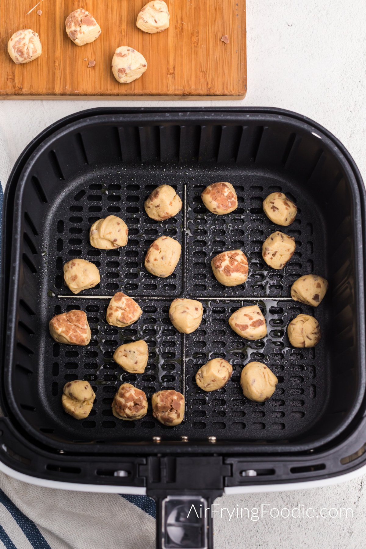 Cinnamon rolld dough balls in a single layer in the basket of the air fryer.