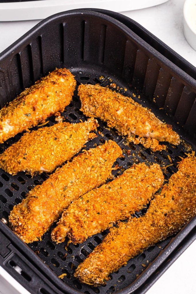 Golden crispy coated chicken in the air fryer basket. 