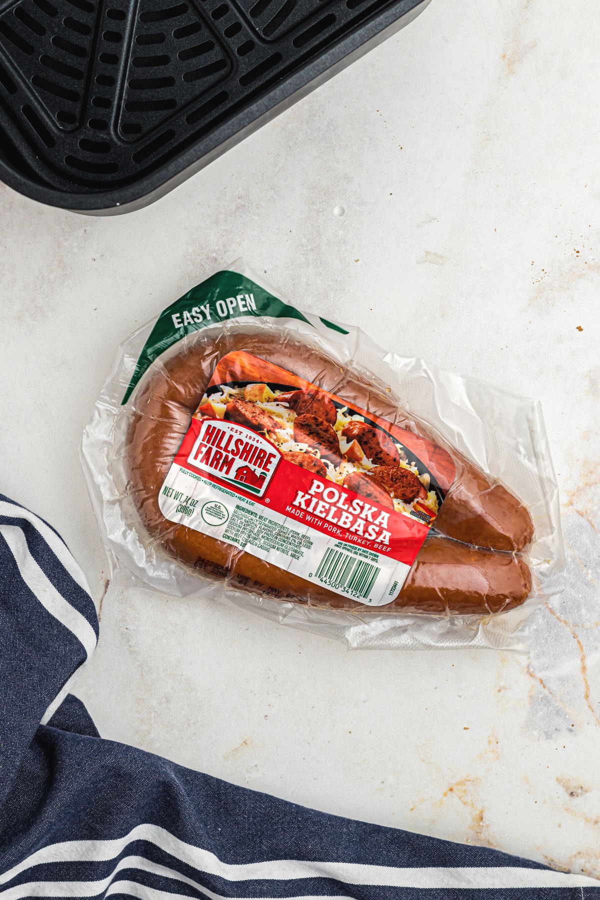 Easy Air Fryer Kielbasa 3 One package of kielbasa on a marble table, ready for preparation.