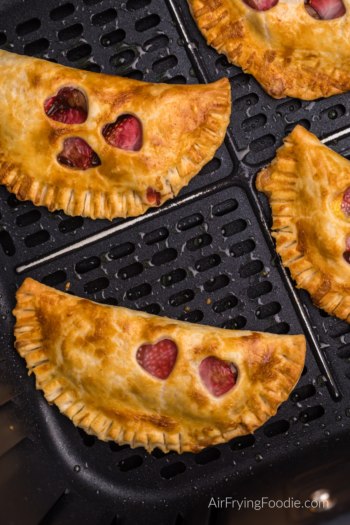 Strawberry Nutella hand pies in the basket of the air fryer, golden brown and ready to serve.