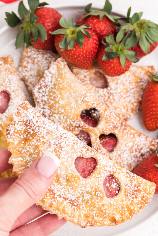 Strawberry nutella hand pies made in the air fryer and ready to eat. One being held.