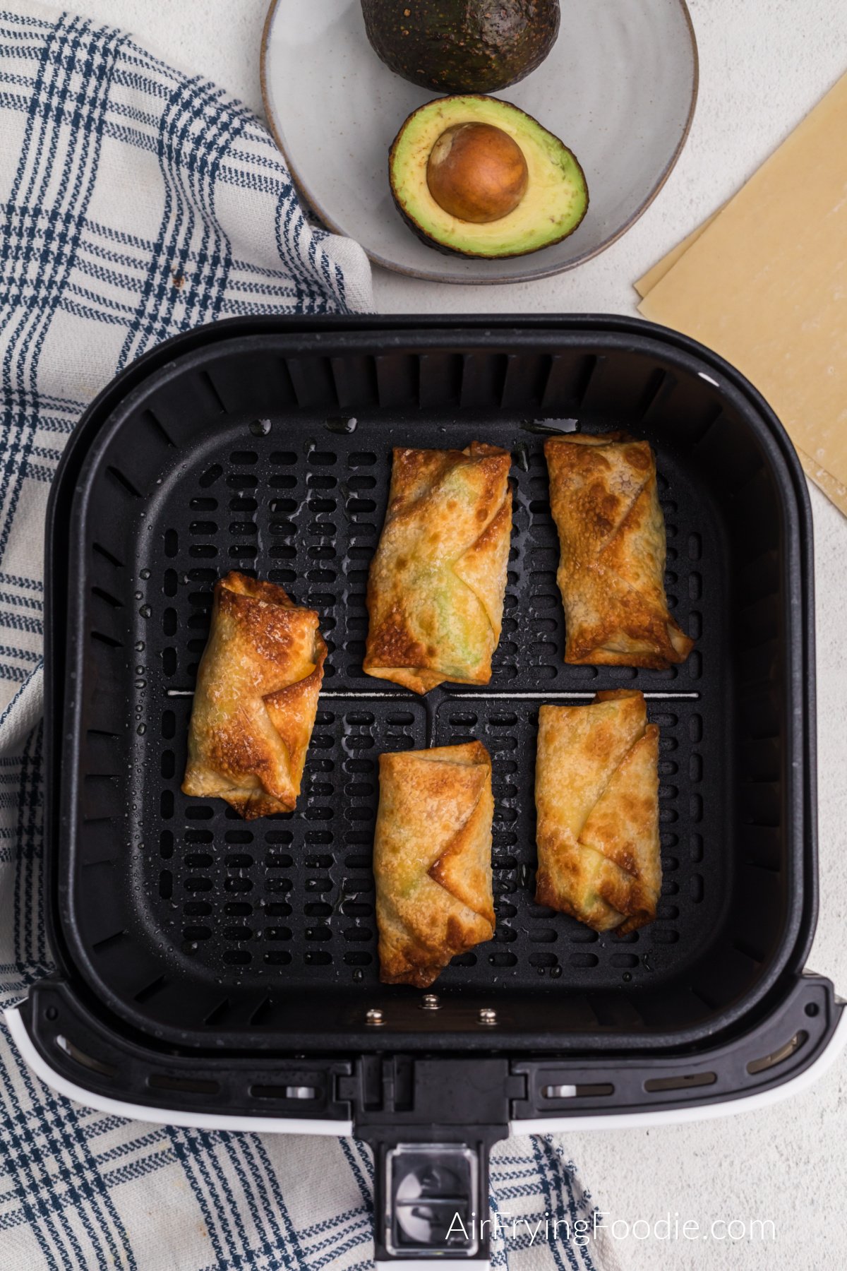 Avocado Bacon egg rolls in the basket of the air fryer.