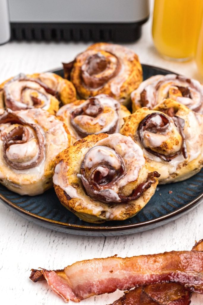 Golden crispy cinnamon rolls wrapped around bacon slices and then frosted.