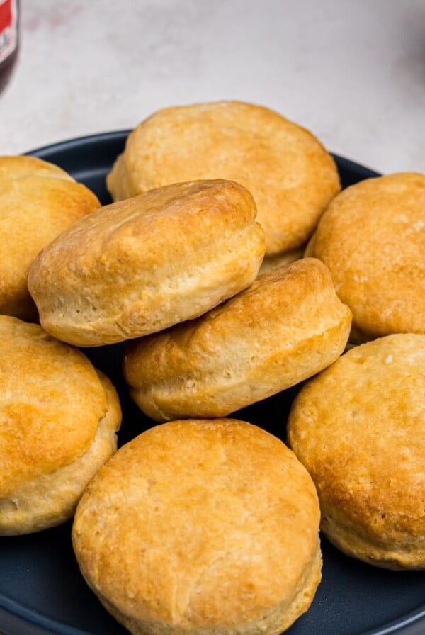 Golden fluffy biscuits stacked on a blue plate.