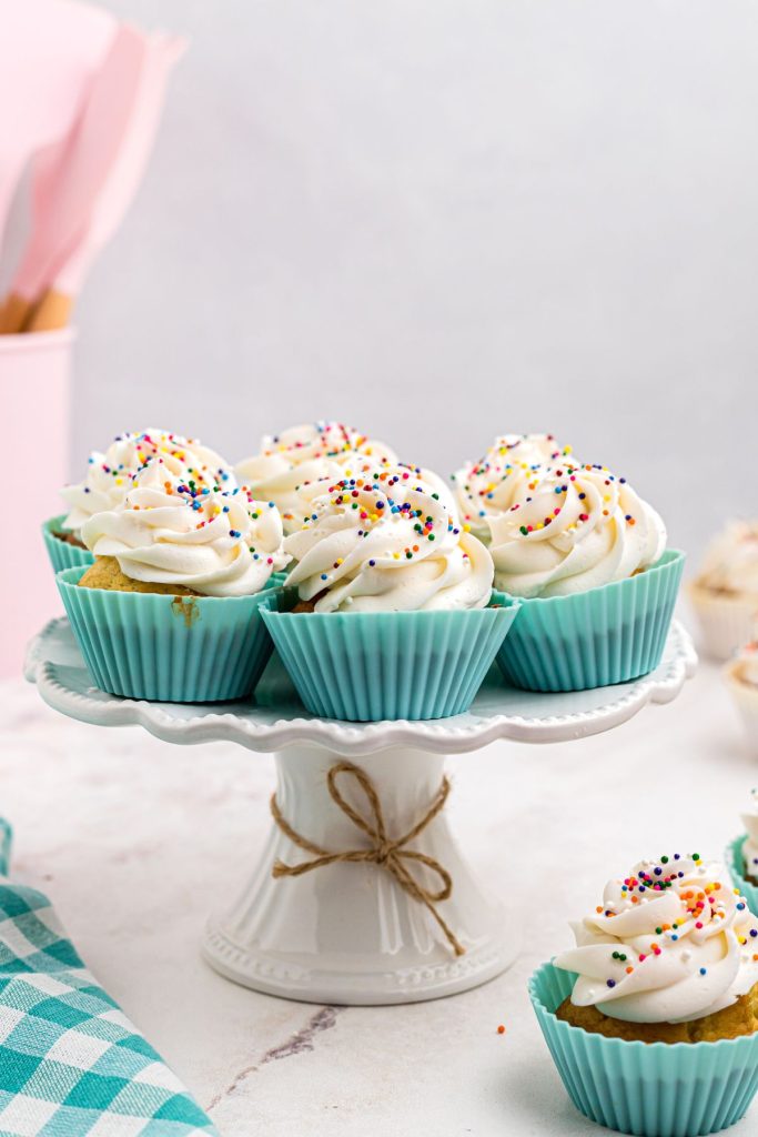 Cupcakes in light blue liners on a white marble cake plate