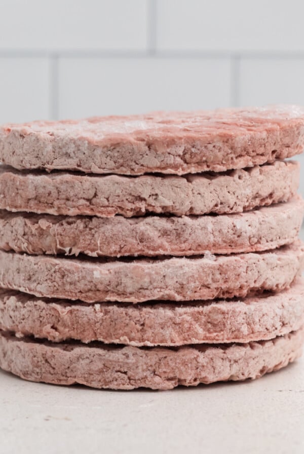 Stacked frozen burger patties ready to be cooked in the air fryer.