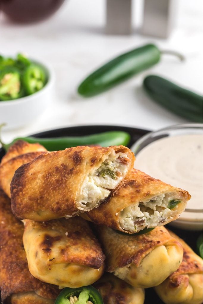 Golden crispy egg rolls filled with cream cheese and chopped jalapenos