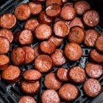 Juicy cooked slices of kielbasa in the air fryer basket.