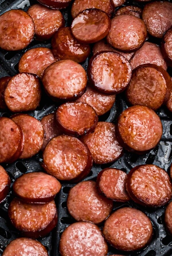 Juicy cooked slices of kielbasa in the air fryer basket.