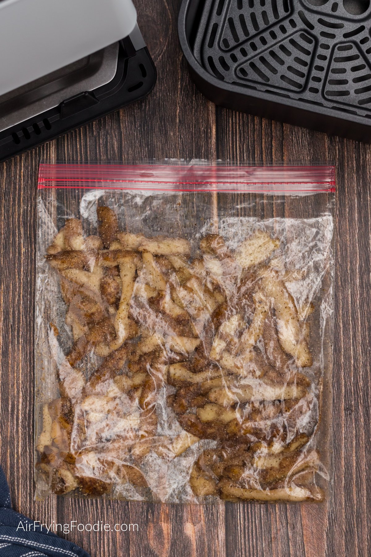 Potato peelings tossed in oil and seasonings in a plastic baggie.