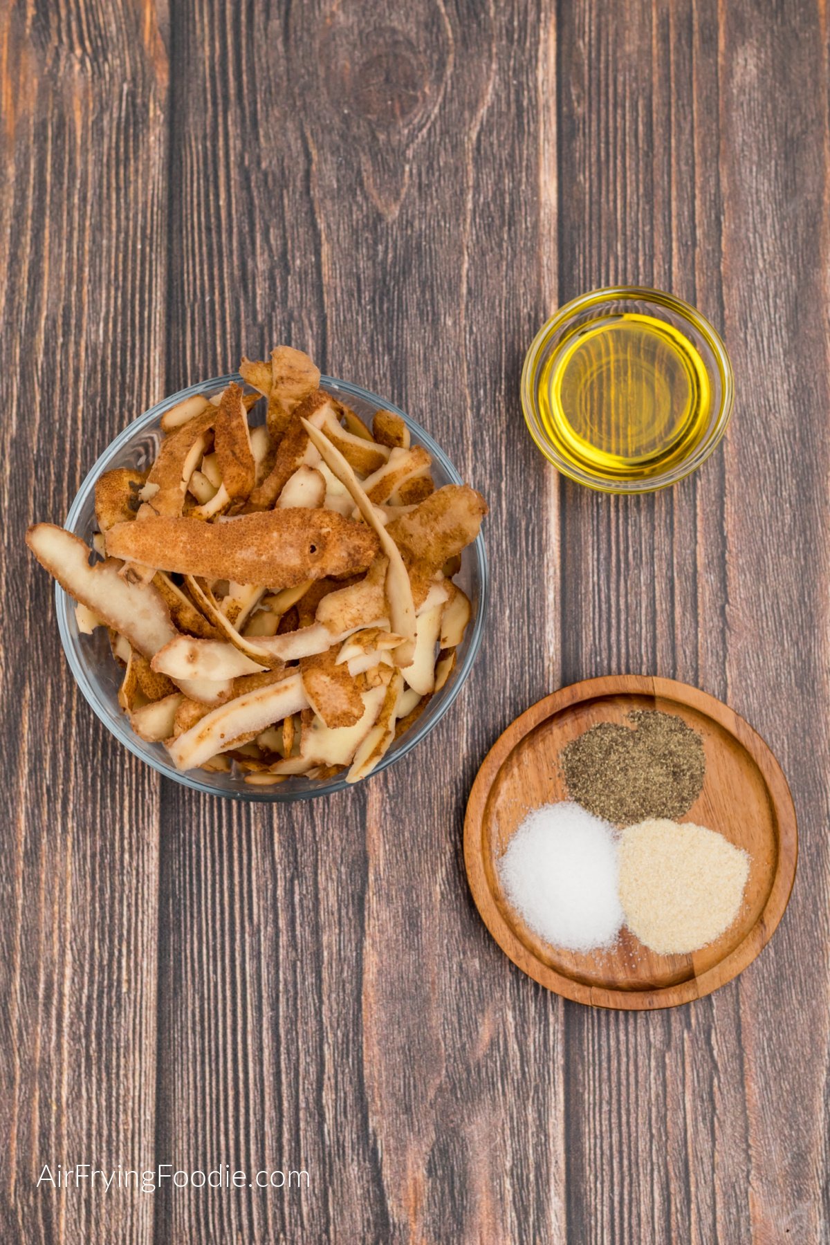 potato peelings in a bowl, oil in a small bowl, and seasonings on a small plate. 