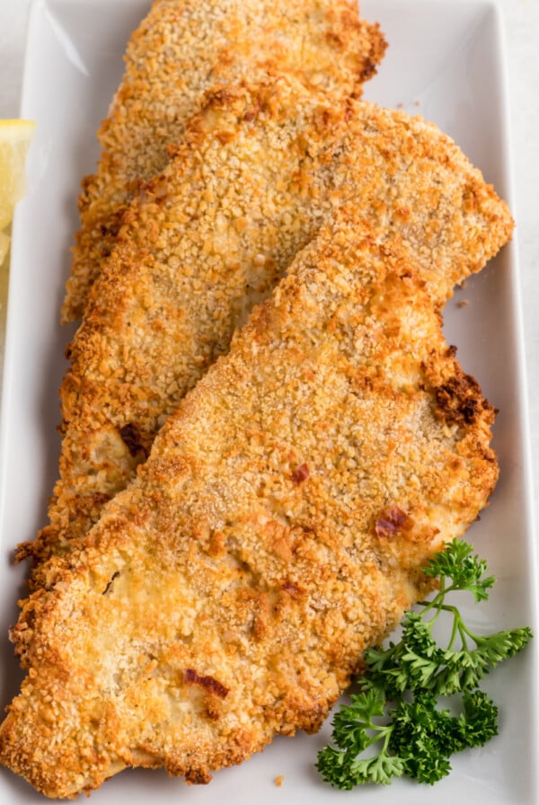 Overhead photo of air fryer fish filets on a plate, ready to serve.