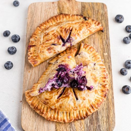 Blueberry hand pies on a cutting board, ready to eat.