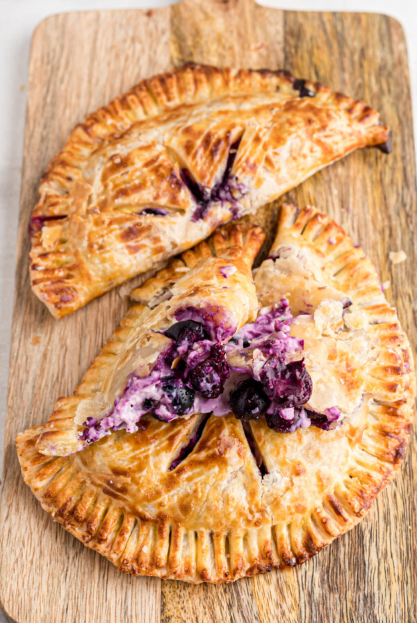 Blueberry hand pies on a cutting board, ready to eat.