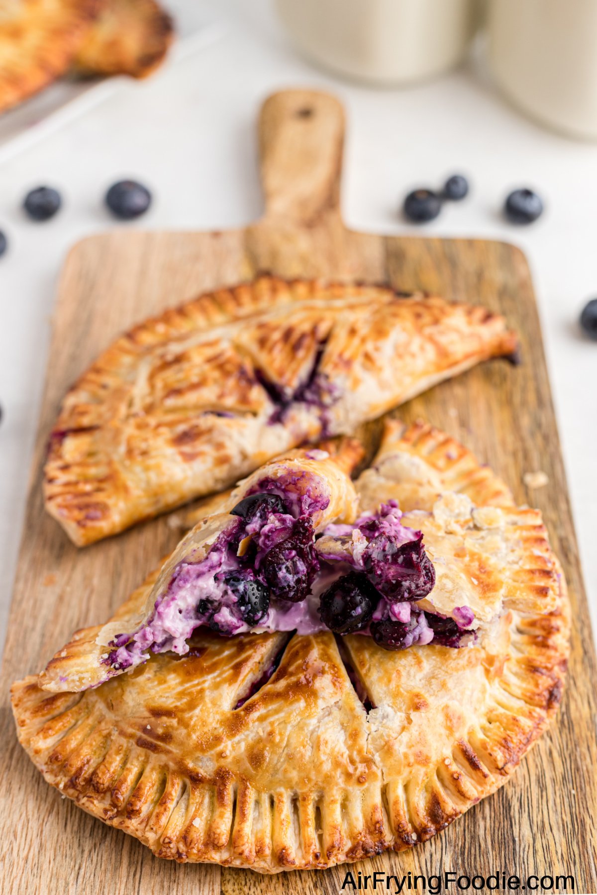 Blueberry hand pies made in an air fryer, and placed on a cutting board.