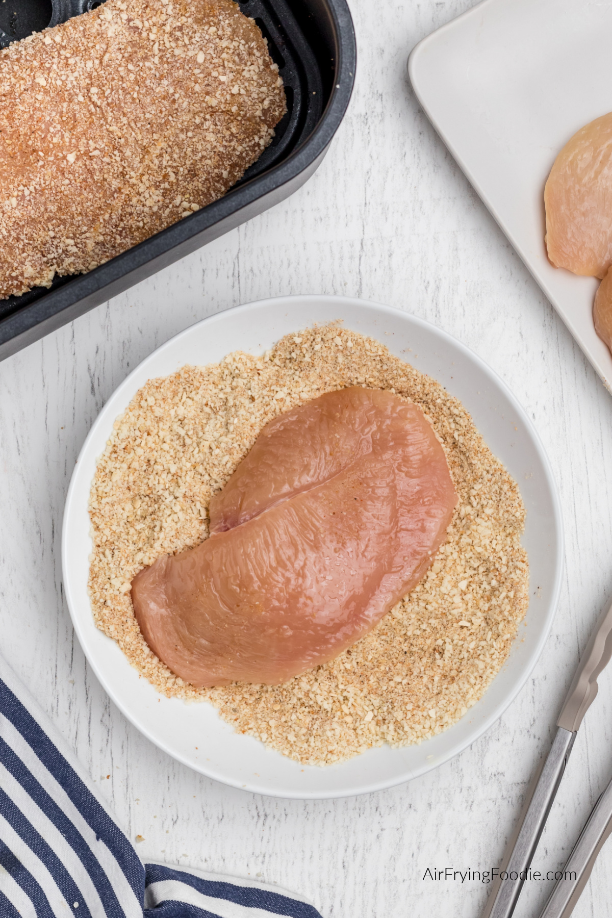 Chicken breast in the breadcrumb and seasoning mixture.