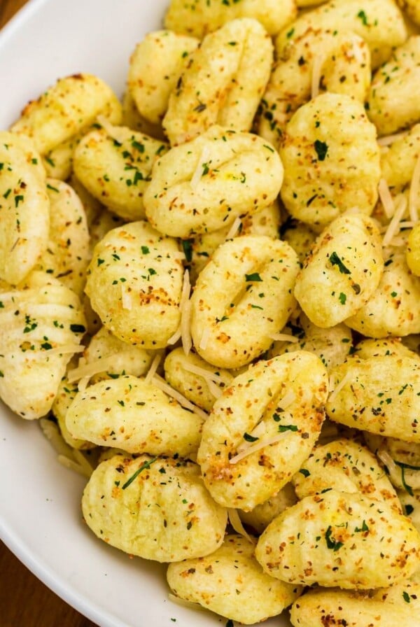 Golden crispy gnocchi in a white bowl, seasoned.