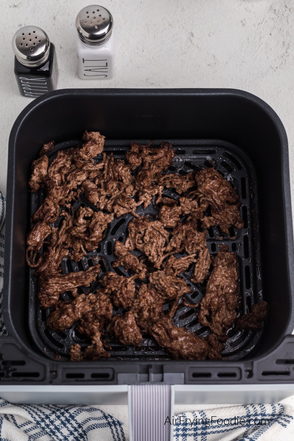 Air fried ground beef in basket of the air fryer, ready to season and serve.