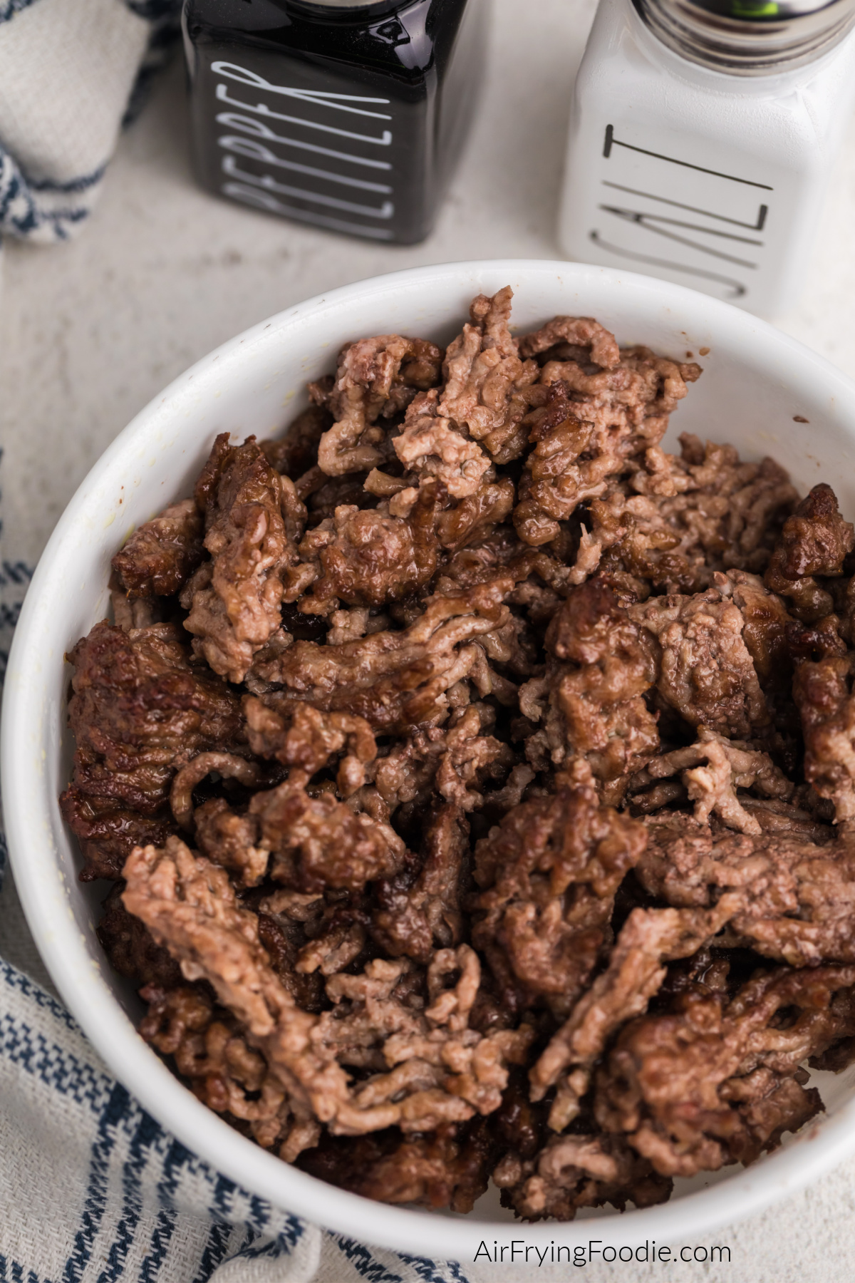 CLose up photo of air fried ground beef in a white bowl.