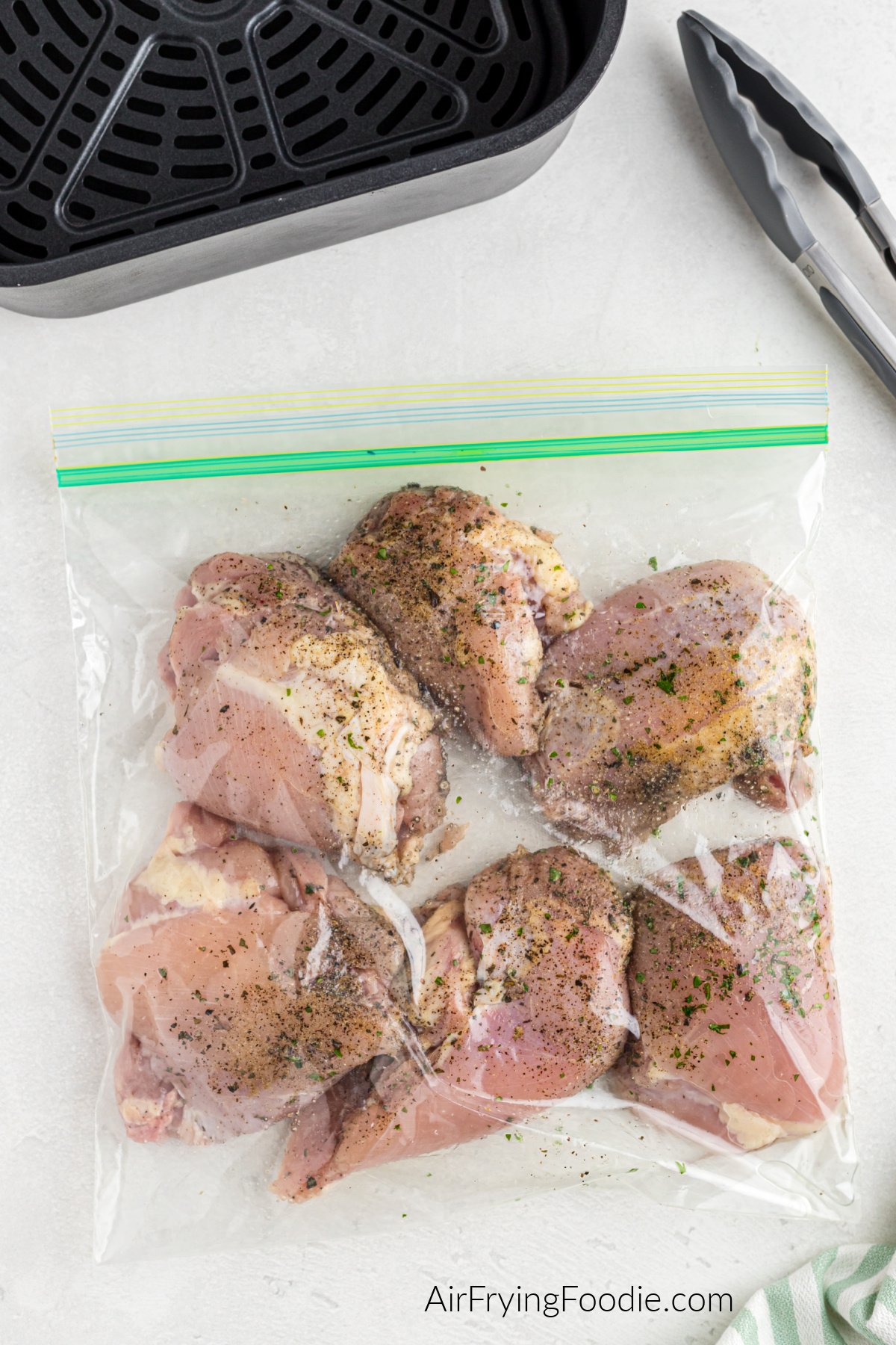 chicken thighs, oil, and seasonings in a sealable plastic bag.