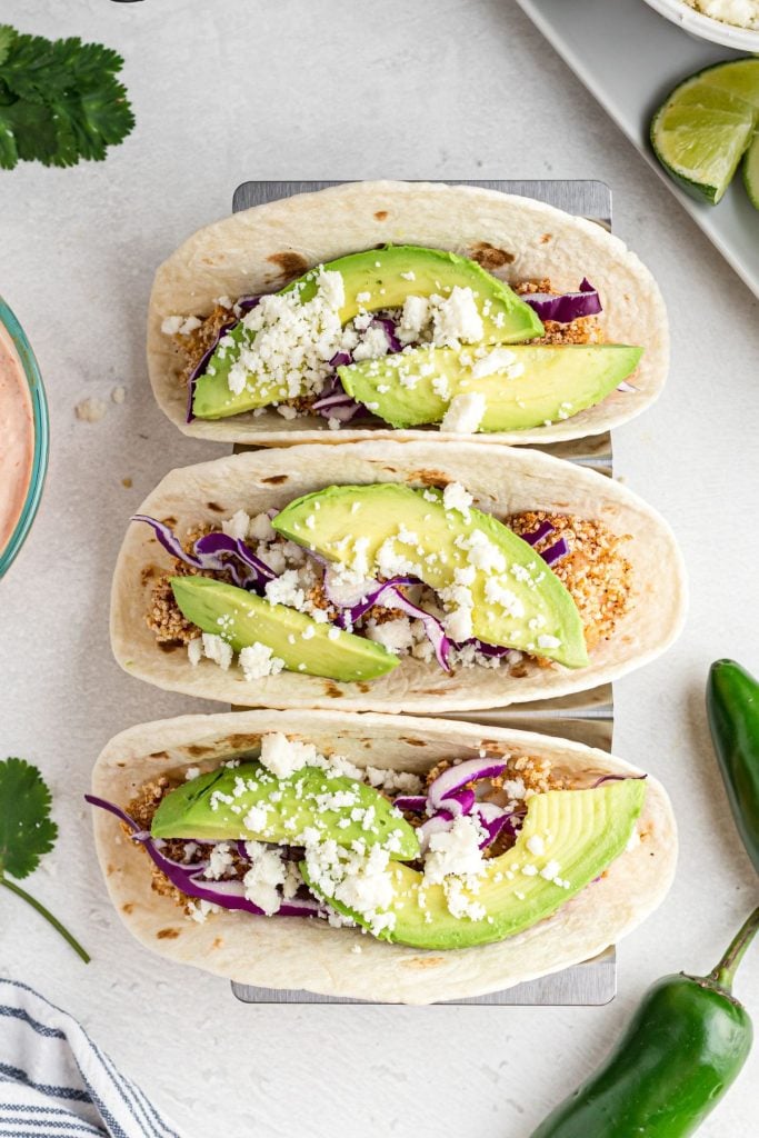 Crispy pieces of fish filling flour tortillas and topped with avocado, cabbage, and corjita cheese