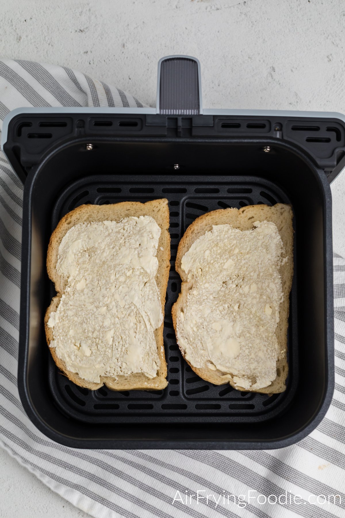 Buttered bread in the basket of the air fryer.
