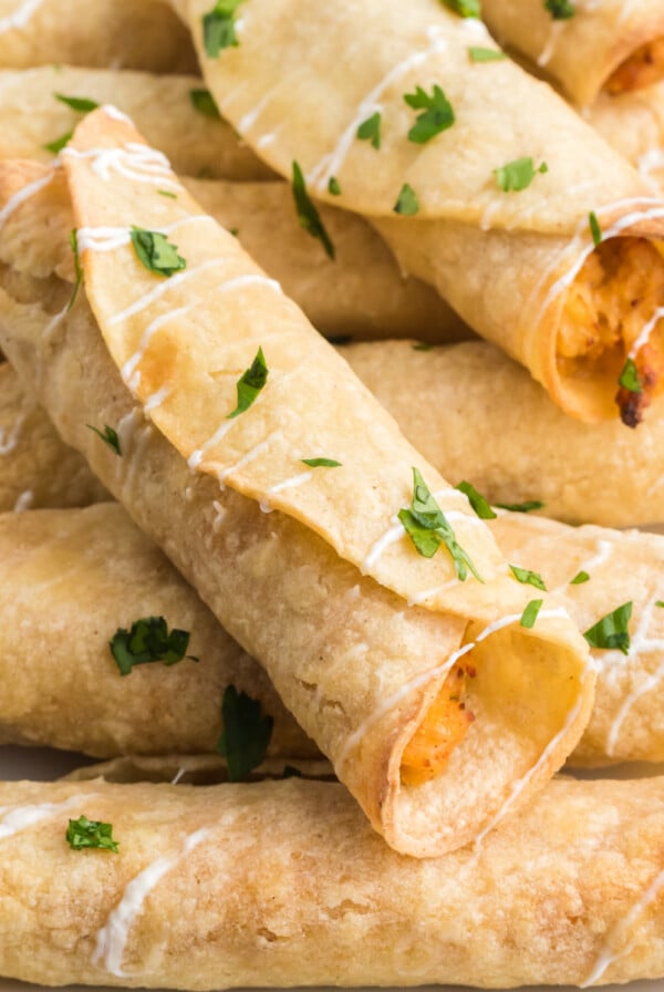 Chicken taquitos made in the air fryer and topped with sour cream and cilantro before serving.