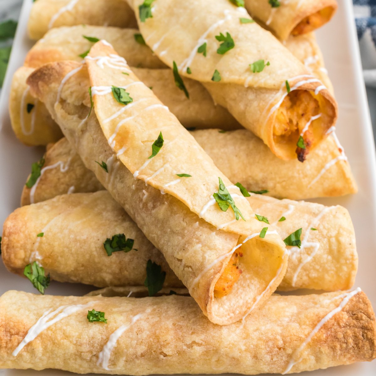 Chicken taquitos made in the air fryer and topped with sour cream and cilantro before serving.