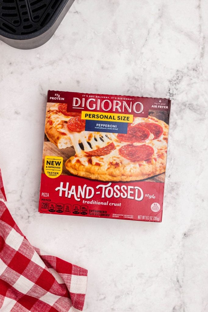 Box of personal size pizza  on a white marble table. 