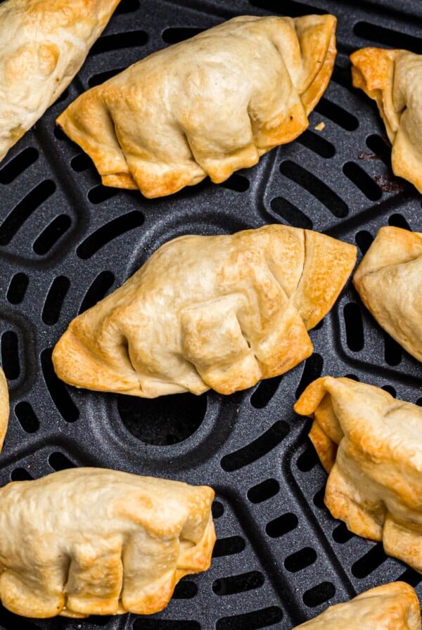 Golden crispy potstickers in the air fryer basket after being cooked.