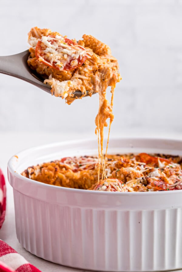 Air fryer Pizza pasta casserole being scooped from the casserole dish.