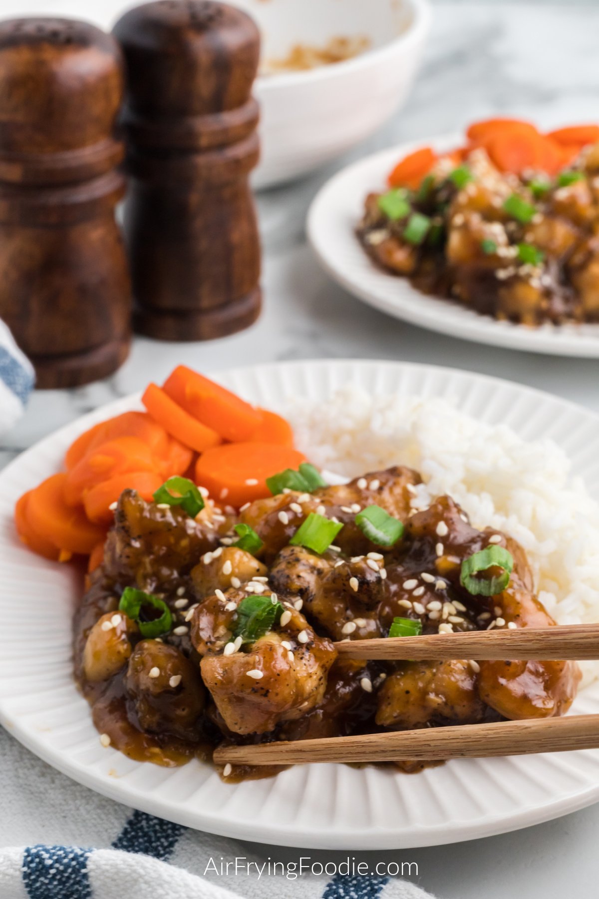 Air Fryer Teriyaki chicken on a plate served with rice and sliced carrots. 