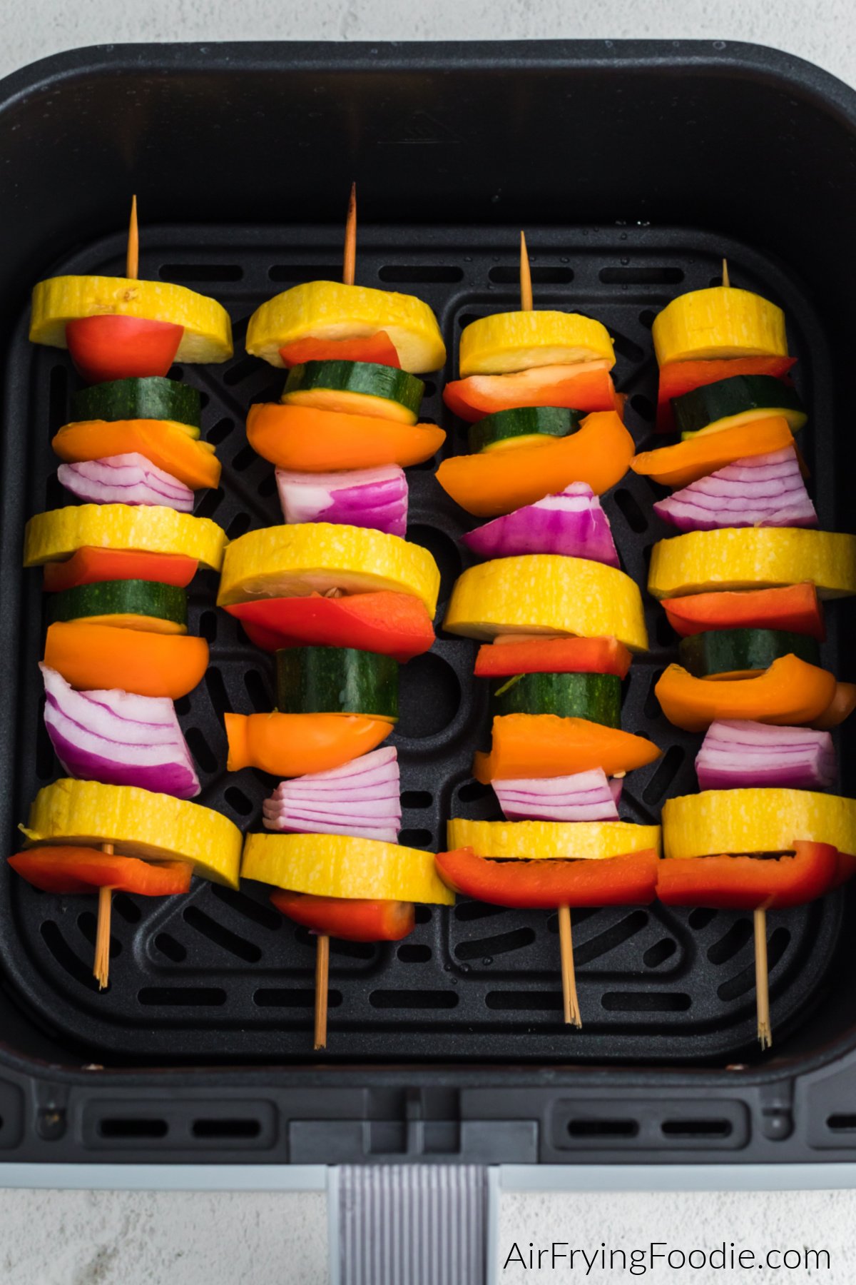 Vegetables rotated on wooden skewers and placed into the basket of the air fryer.