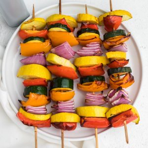 Vegetable kabobs made in the air fryer and served on a white plate.