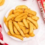 Seasoned Red Robin steak fries on a white plate with a small bowl of ketchup.