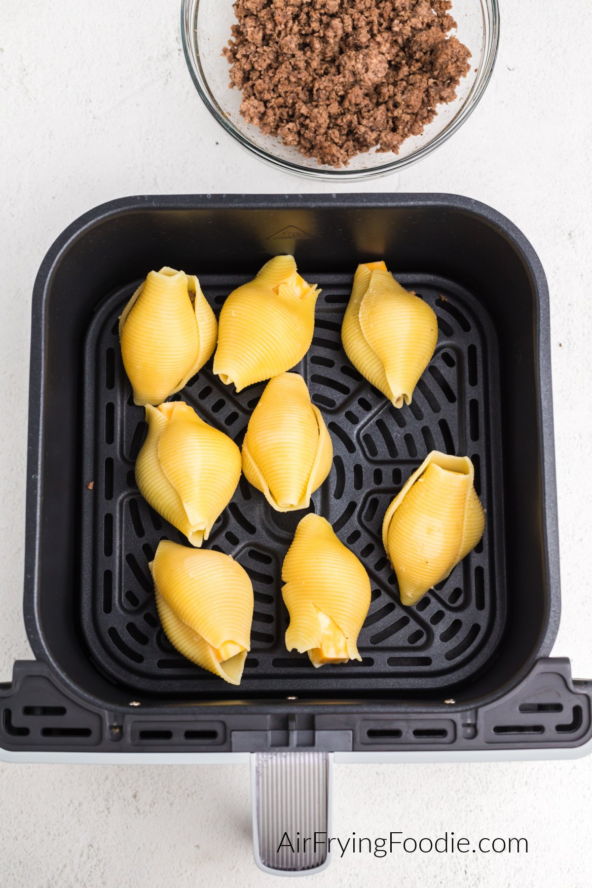 Stuffed shells in the basket of the air fryer, ready to cook.