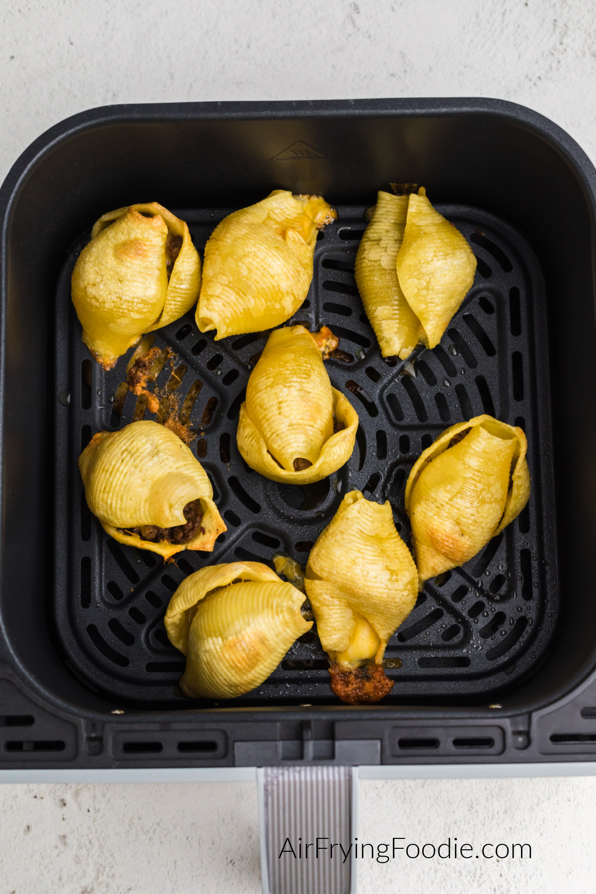 Air fried Taco Stuffed shells in the basket of the air fryer.