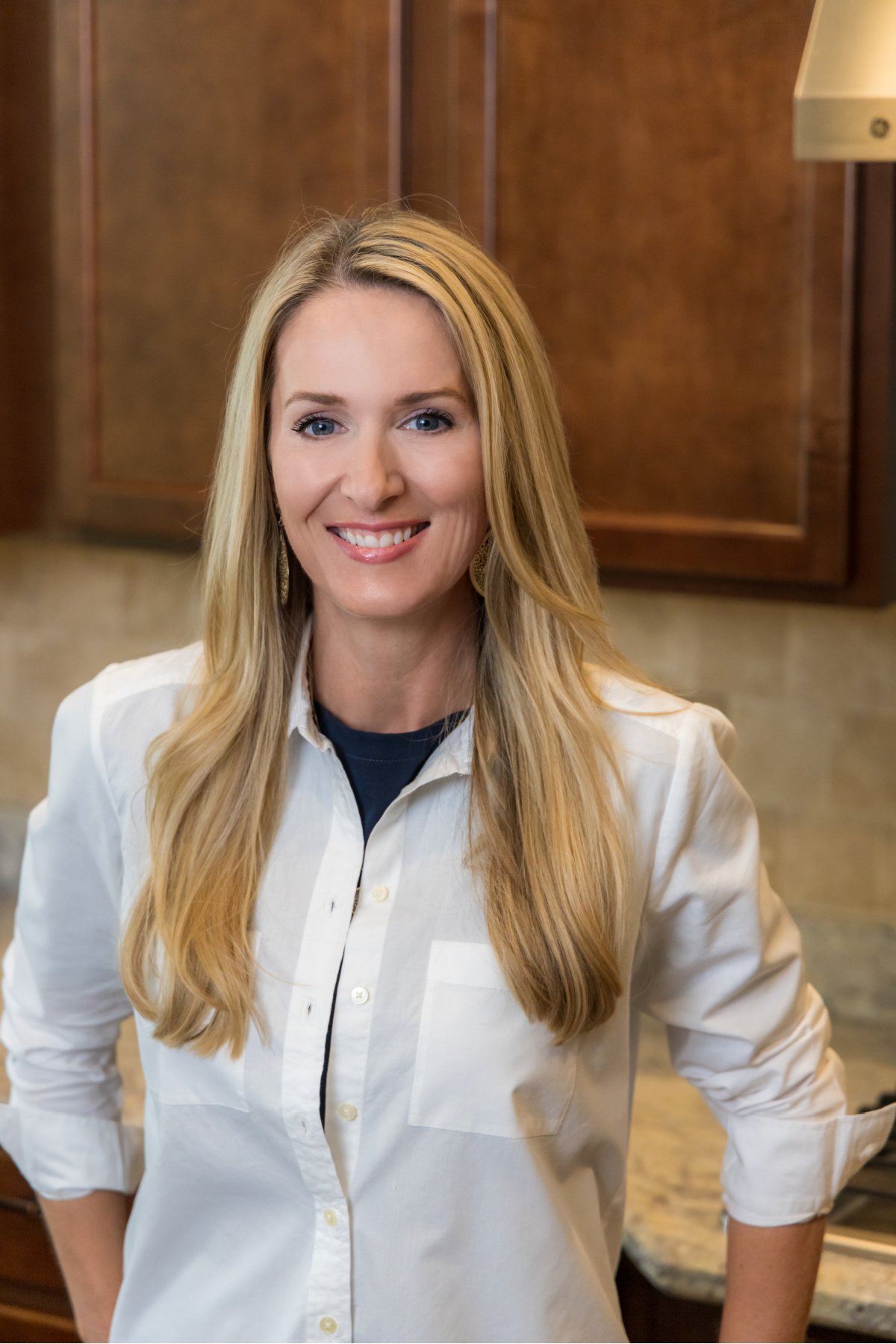 Author, recipe developer, and content creator for air frying foode, Jennifer West. Standing in the kitchen.