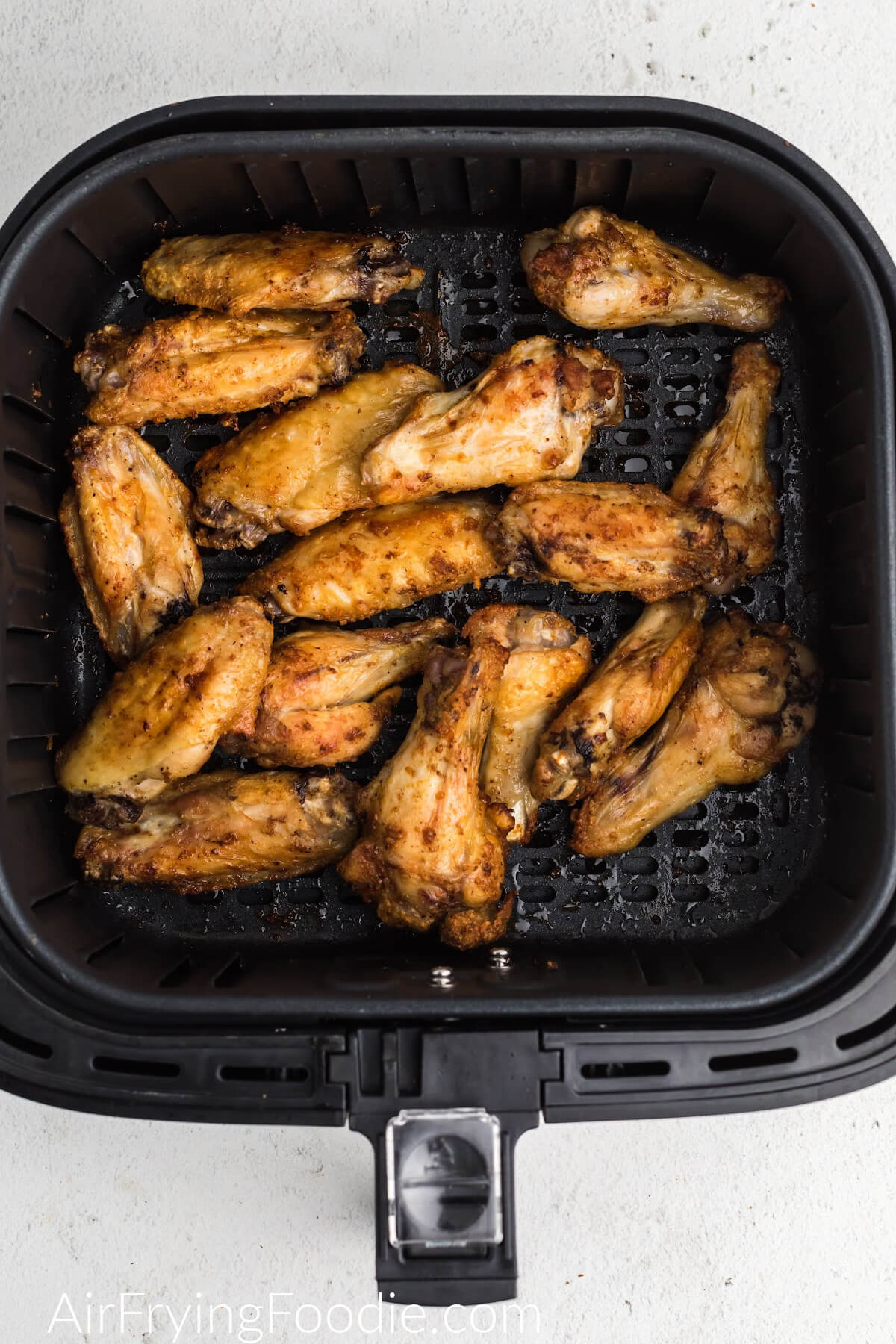 Chicken wings in the air fryer basket.
