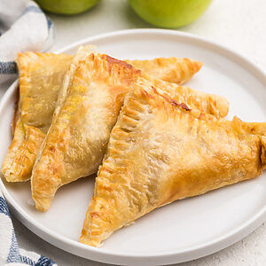 Air fried apple turnovers on a white plate, ready to eat.