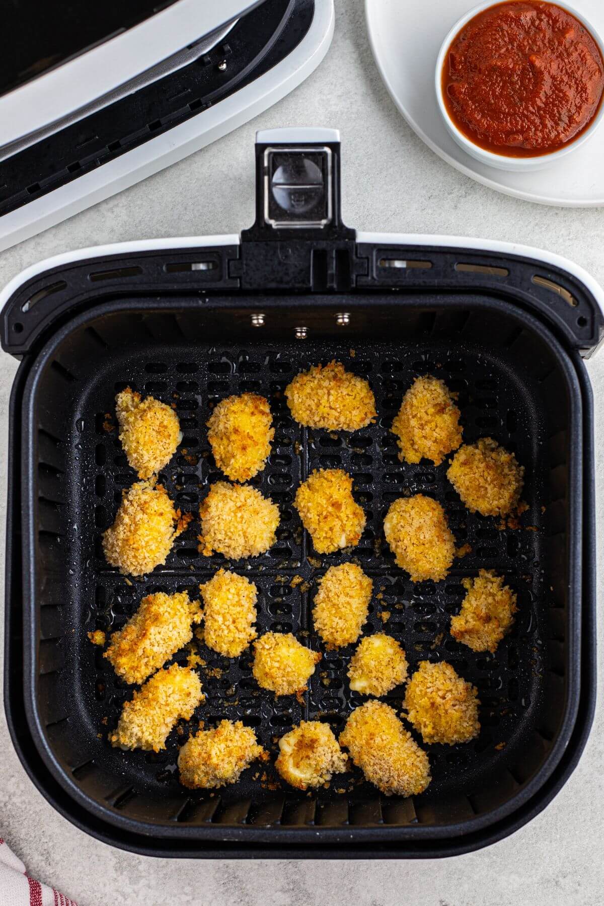 Golden fried breaded cheese curds in the air fryer basket. 