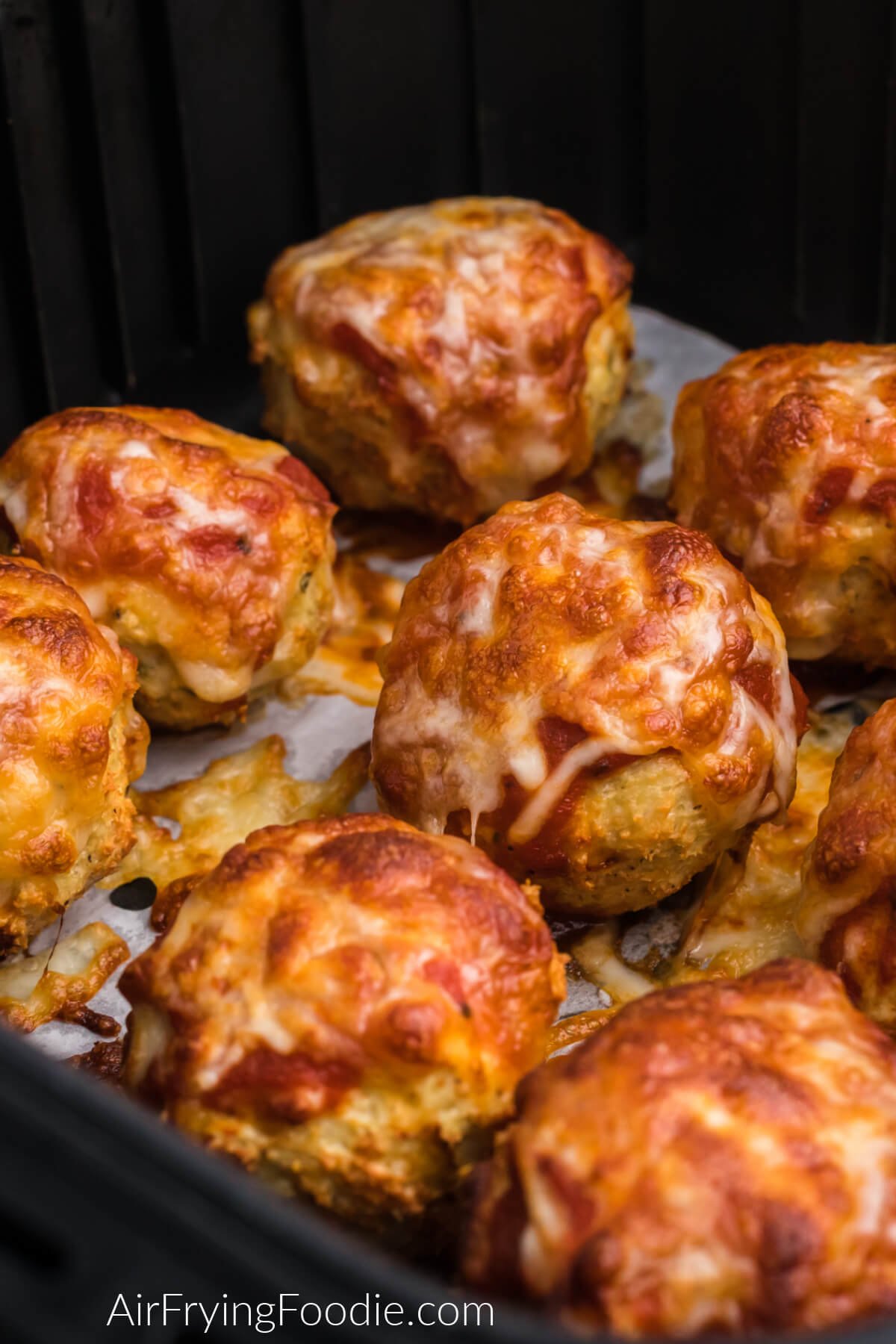 Fully cooked air fryer chicken meatballs topped with marinara and cheese and ready to be served. 