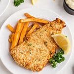 Leftover fish reheated in air fryer and served with fries and a lemon slice.