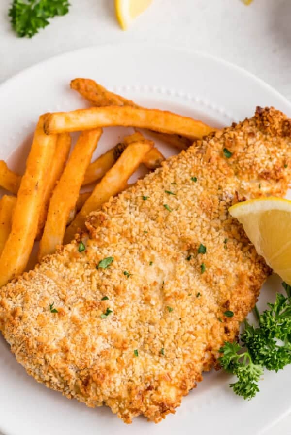 Leftover fish reheated in air fryer and served with fries and a lemon slice.