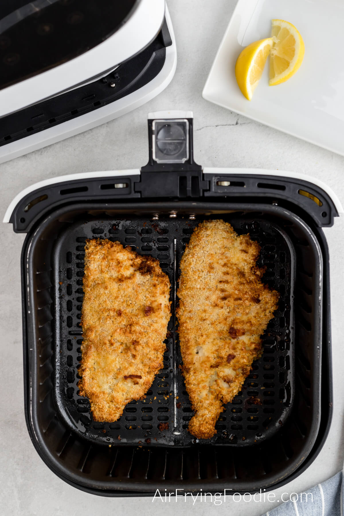 Fish in a single layer in the air fryer basket, ready to be reheated. 