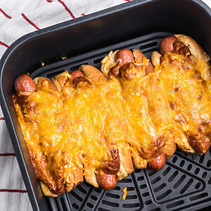 Air Fried Chili cheese dogs in the air fryer basket, ready to serve.