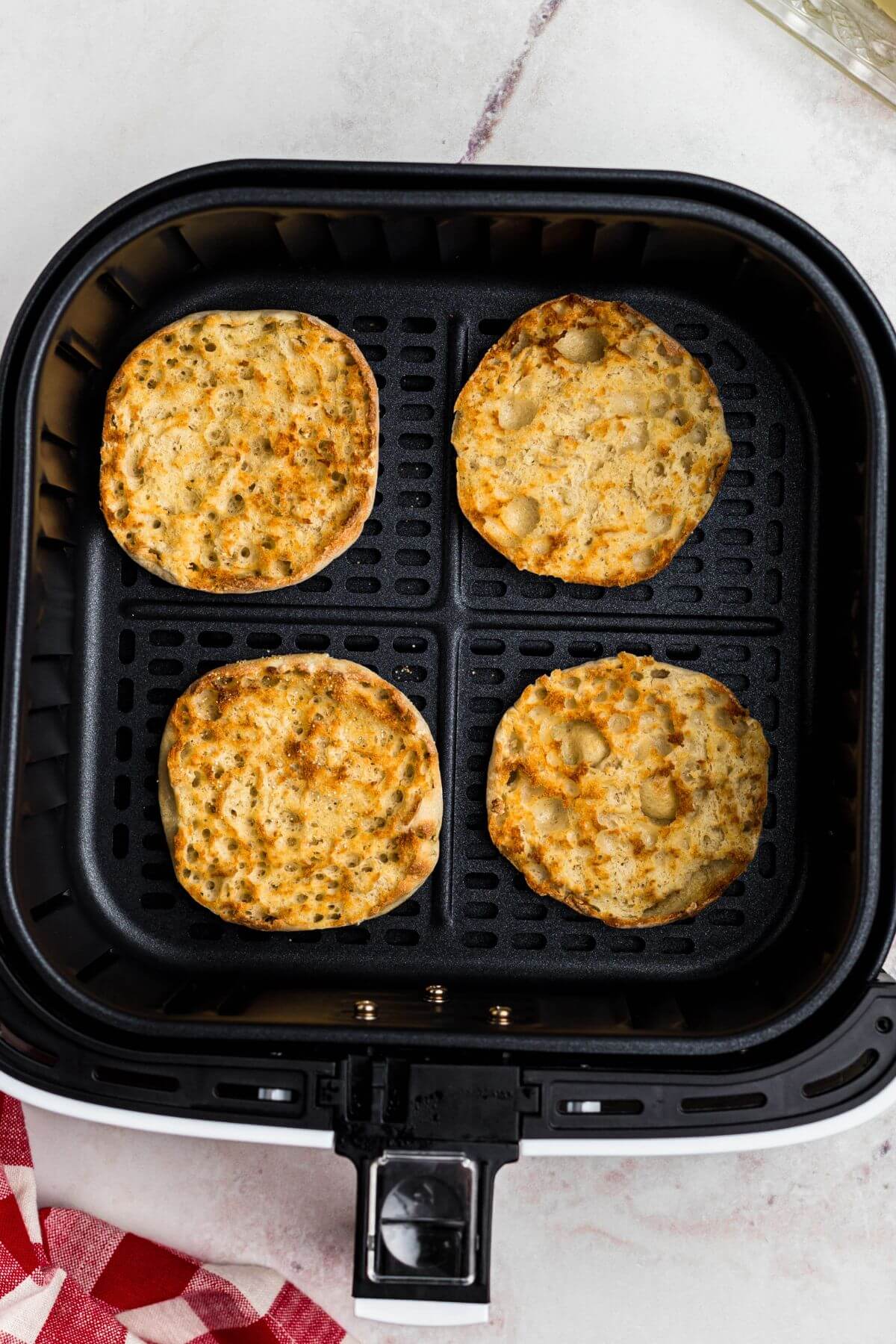 Golden crispy English muffins in the air fryer basket. 